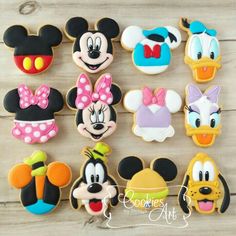 mickey and minnie mouse cookies are arranged on a wooden table with the words disney written in it