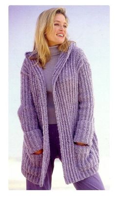 a woman is smiling while wearing a purple cardigan sweater and purple pants with her hands in her pockets