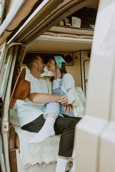 a man and woman sitting in the back of a van