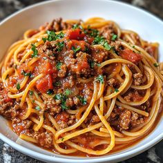 a white bowl filled with spaghetti and meat