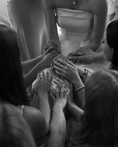 a group of women standing next to each other in front of a woman wearing a dress