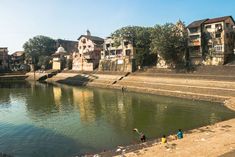 some people are standing on the bank of a river