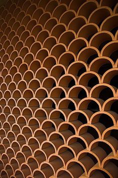 an abstract photo of circles and rings on a wall made of concrete blocks, with the light shining through them