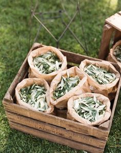 several bags filled with food sitting on top of a grass covered field next to a wooden crate