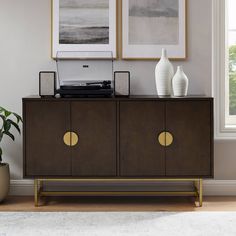 a brown cabinet with two white vases on top