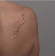 a cat tattoo on the back of a woman's shoulder