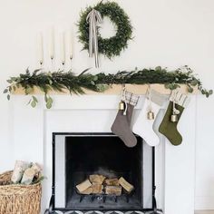 a fireplace decorated for christmas with stockings hanging from the mantel and wreath on top