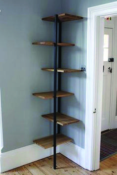 a corner shelf in the corner of a room with wood floors and gray walls, next to a white door