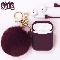 an earphone case with a pom - pom keychain attached to it