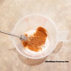 a whisk in a measuring cup filled with spices