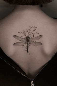 a woman with a dragonfly tattoo on her back