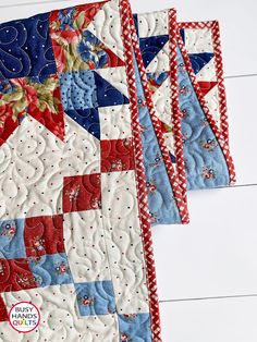 three red, white and blue quilted placemats sitting on top of each other