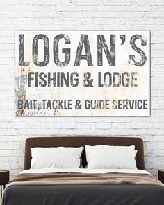 a bed sitting in front of a brick wall with a sign above it that says logan's fishing and lodge