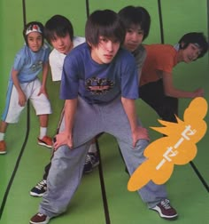 a group of young men standing next to each other on top of a green floor