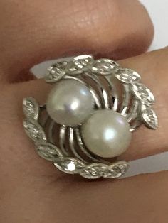 Details: A Unique and one of a kind Ring Handmade Vintage Ring Custom Made Ring (Estimated Late 1960's Early 1970's) 14Karat White Gold Ring Shank is nice and wide 2 Cultured Pearls in the Center One Pearl color is White the other has a silver tone color There are 12 diamond Stones around the Crown Estimate Total Weight .25ct Ring weight : 7.3 Grams Ring is appraised for the value of $2750 Since the following ring is Vintage no changes will be made to the ring Ring will be shipped via FEDEX seco Round Diamond Pearl Ring, Vintage Multi-stone Diamond Rings, Fine Jewelry Round Cut Pearl Ring For Anniversary, Diamond White Platinum Pearl Ring For Anniversary, Platinum Pearl Ring In Diamond White For Anniversary, Diamond White Multi-stone Round Ring, Art Deco White Gold Rings Stamped 14k, White Gold Art Deco Rings Stamped 14k, Elegant 14k White Gold Rings Stamped 14k