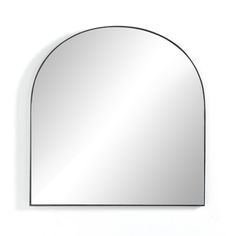 an arch shaped mirror hanging on the wall