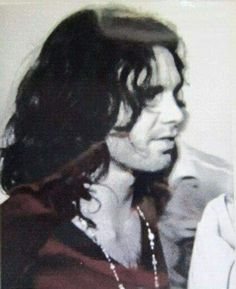 a black and white photo of a man with long hair