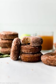 several donuts stacked on top of each other next to a glass of orange juice