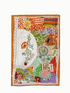 an orange and white patchwork quilt with flowers on the front, along with other colorful fabrics