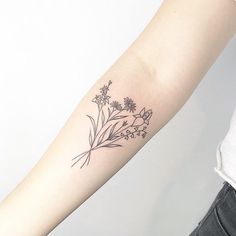 a woman's arm with a flower tattoo on the left side of her arm