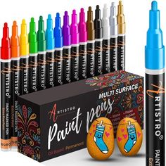 an assortment of markers and pens in front of a box with each one painted different colors