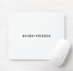 a white mouse pad with the words books = friends on it next to a computer mouse