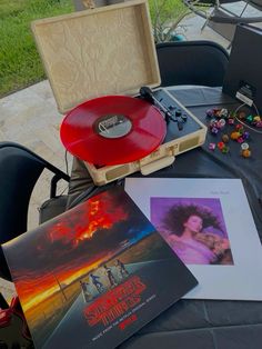 an old record player sitting on top of a table next to other records and cds