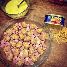 a bowl filled with tater tots and cheese next to a can of mustard