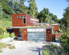 a modern house in the woods with lots of greenery on it's roof