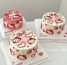 three hello kitty themed cakes sitting on top of white trays with red and pink frosting