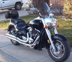 a motorcycle is parked on the sidewalk in front of a house