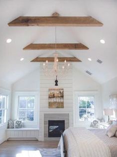 a bedroom with a fireplace and chandelier hanging from the ceiling