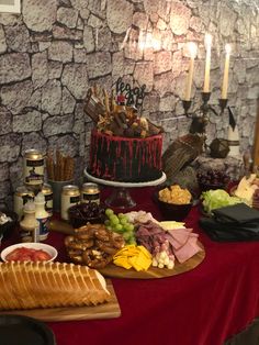 a table topped with lots of food next to a wall covered in candles and other items