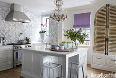 an image of a kitchen with white cabinets and silver counter tops on the phone screen