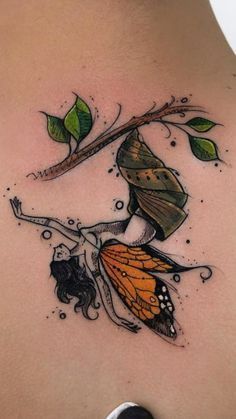 a woman with a butterfly tattoo on her back and shoulder, holding onto a branch