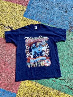 Vintage 1999 New York Yankees MLB Baseball World Series Champions Parking Lot Bootleg Graphic Shirt Size XL    You are viewing a VTG Yankees World Series Tee    Fruit of the Loom Tag  EXCELLENT Condition  FRONT Graphic  100% Cotton  Measurements: 29.5" LONG, 22" WIDE and 33.5" Sleeve-to-sleeve         Terms: Vintage clothing sizing varies and may have minor cosmetic imperfections. We recommend measuring one of your favorite pieces to compare! Will ship as soon as possible AFTER receiving payment. Please ask any questions or request more pictures if you have additional concerns. NO RETURNS, sold as is. Vintage Baseball Shirt, Vintage Mlb Shirt, Yankees Shirt, Vintage Crew Neck T-shirt Made In Usa, Vintage Crew Neck Sports T-shirt, Vintage Baseball Fan Merchandise T-shirt, Baseball World Series, Yankees World Series, Mlb Baseball