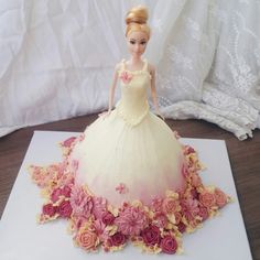 there is a cake made to look like a princess in a dress with flowers on it