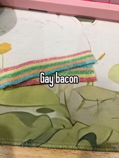 someone is laying down on the floor with their hand in front of them that says gay bacon