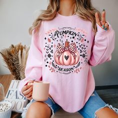 Introducing our Gildan  crewneck sweatshirt. It's so soft and super comfy and will surely be one of your very favorites. Cute graphics of Pink Coquette Pumpkin season.  This shirt would make a great gift for families heading out to the pumpkin patch, halloween party shirt or anyone looking for a cute sweater to add to their fall wardrobe. Ideal for any situation, a unisex heavy blend crewneck sweatshirt is pure comfort. These garments are made from polyester and cotton. This combination helps de Pink T-shirt For Fall Loungewear, Cute Fall T-shirt, Pink T-shirt For Fall, Pumpkin Patch Shirts, Coquette Pumpkin, Coquette Halloween, Halloween Top, Patches Shirt, Comfort Colors Tshirt