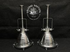 two silver candlesticks sitting next to each other on a black tablecloth background