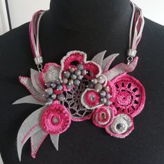 a close up of a necklace on a mannequin headdress with flowers