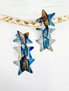 Handmade in Brazil. These three radiant dangling stars in a row will add eye catching sparkle to your collection. Approximately 2 1/4" long 1" at widest part The Row, Brazil, Sparkle, Stars