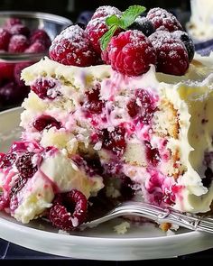 a close up of a piece of cake on a plate with raspberries and powdered sugar