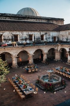 an old building with tables and chairs in the courtyard, next to a large dome