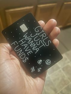 a person holding up a small black card with writing on it