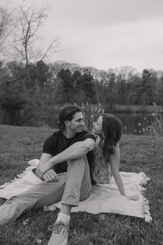 Couple sits on blanket while smiling at each other. Couples Photoshoot Poses Sitting, Sitting Down Poses Couple, Couple Pose Sitting, Park Engagement Shoot, Sitting Down Engagement Photos, Sitting Couples Poses, Engagement Photos In A Park, Sitting Engagement Photos, Sitting Down Couple Poses