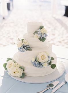 a white wedding cake with blue and white flowers