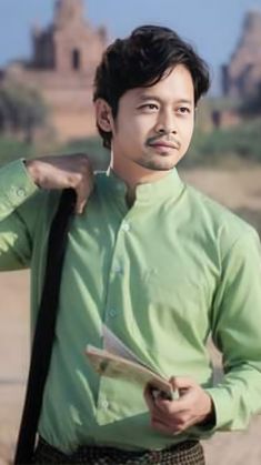 a man in a green shirt and tie holding a clipboard with his hand on his shoulder