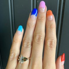 a woman's hand with two different colored nail polishes on it and an engagement ring