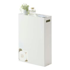 a white toilet paper dispenser with a plant in it